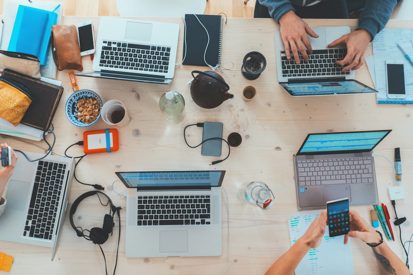 Een marketingteam werkt aan laptops rond een gezamenlijke tafel